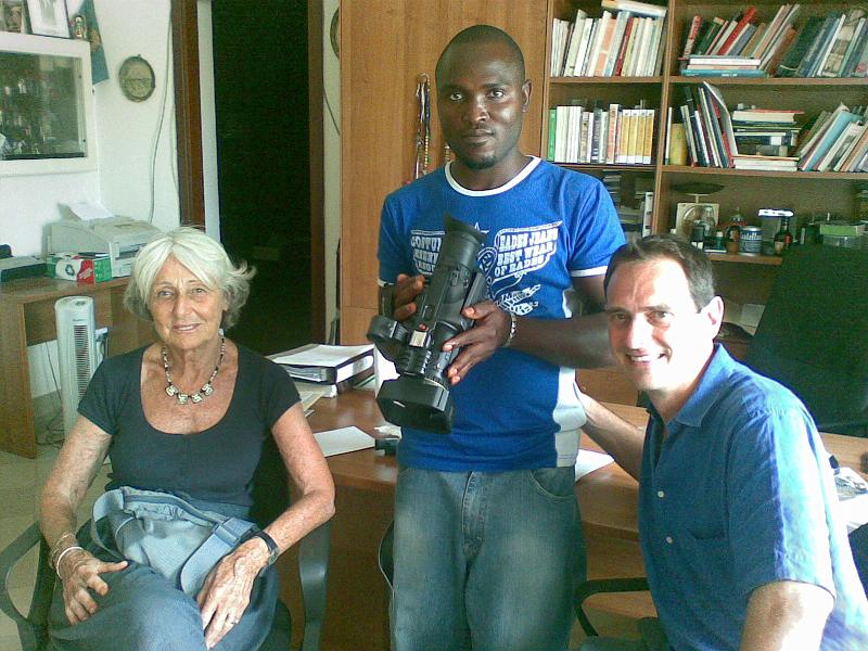 090720094647.jpg - Angelo Loy si complimenta con il giovane nigeriano alle prese con la nuova telecamera offerta dalla signora Rosetta